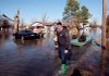 Larry Thurston, who has difficulty walking, is evacuated Saturday after he reported 2 feet of floodwater in his house on North G Street in the Dixie Addition of North Little Rock on Saturday. North Little Rock firefighters (left to right) Capt. Bo Buford, Michael Sanchez (hidden by Buford) and Greg Brown pulled the boat.
