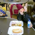 Orion General, 2, and Alissa Creech, 7, eat a Christmas dinner Friday at the Bentonville Church of C...