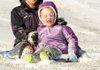 Chloe Cooper, 6, gets a face full of snow Friday while riding with Courtney Nixon in Bentonville. The two were sledding a popular hill along North Walton Boulevard.