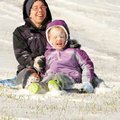 Chloe Cooper, 6, gets a face full of snow Friday while riding with Courtney Nixon in Bentonville. Th...