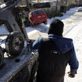 SLIPPERY SEASON
Kenneth Cox, with Greenland Wrecker Service, works to pull a Pontiac Matrix from a ...