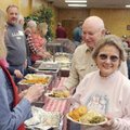 Jim and Rae Oden go through the serving line Friday for a Christmas dinner at the Central United Met...
