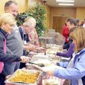 Chris Benningfield serves sweet potatoes Friday to Sabrina Freeman during the Central United Methodi...