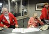 Helen Hammond, middle, Stephen Keane, left, and Adam Wilcox, right, volunteer at the information desk in Northwest Medical Center in Springdale on Thursday.
