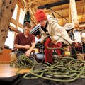 Jackson White, 10, of Springdale, right, helps Cole Fennel, Pack Rat Outdoor Center salesman, untang...