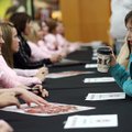 Signing Rylee Rogers, 7, of Fayetteville gets a smile from Razorback senior gymnast Casey Jo Magee w...