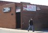 Dell Hall of Fayetteville, whose family owns longtime Fayetteville business World Tresures, walks along Block Avenue Thursday, Dec. 17, 2009, past Maxine's Tap Room which is closed during December. Andrea Foren, owner of the longtime bar, plans to reopen Jan. 8.