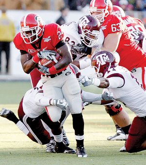 Georgia tailback Washaun Ealey (25) runs past Texas A&M defenders in the first quarter of Monday’s Independence Bowl in Shreveport. Ealey finished with 78 yards rushing in the 44-20 Georgia victory. 