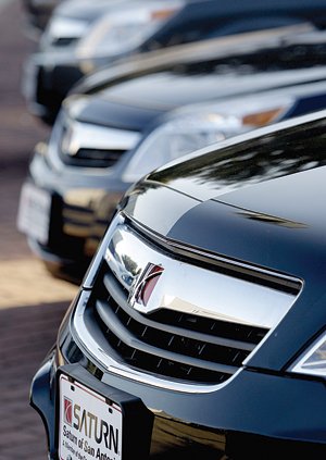 New Saturn automobiles sit on a lot in San Antonio in this February 2009 file photo. General Motors Co. is offering deep discounts to dealers on the remaining Saturn and Pontiac vehicles.