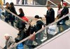 In this file photo made Dec. 19, 2009, shoppers ride escalators at Water Tower Place in Chicago.  Holiday shoppers spent a little more this season, according to data released Monday