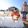 Hannah Blankenship, 7, right, and her brother, Hunter Blankenship, 10, pack snow into buckets while ...