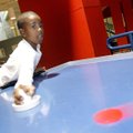 Kevin Smith, 10, of Springdale stretches to make contact with the puck while playing air hockey Mond...