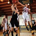 Bentonville’s Grant Higgins takes the ball to the basket under pressure from McDonald County (Mo.) g...