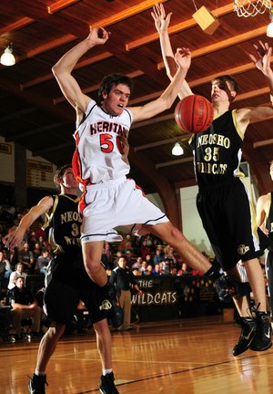 Rogers Heritage’s Anibal Avila is fouled on his way to the basket by Neosho (Mo.) forward Corey Crandall during Tuesday’s game at the 55th annual Neosho Holiday Tournament in Neosho, Mo.
