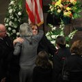 Salvation Army Maj. Jimmy Bovender (left) stands by as his daughter Cindy Wise hugs mourners Tuesday...