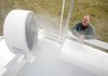   In this photo taken Tuesday, Dec. 8, 2009, Garth Patterson watches as cooling mist sprays out of a misting fan on his portable cooling station in Napa, Calif.  After watching grape harvesters toil in the vineyards on a summer day without shade, Patterson was inspired to provide relief wherever farmworkers happened to be. 