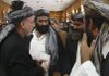 Afghan President Hamid Karzai (center) offers condolences Saturday to people in Lashkar Gah who lost family members in a recent airstrike. 