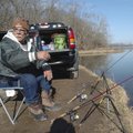 Kosta Platanitis of Rogers checks on nearby anglers Friday at Lake Atalanta in Rogers while pursuing...