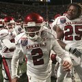 Arkansas kicker Alex Tejada is surrounded by teammates after kicking a game winning field goal in ov...