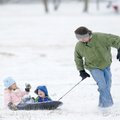 Chip Bemis of Fayetteville pulls his daughter, Kessiah, 5, and son, Oliver, 3, in a sled Sunday in a...