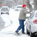 oel Garcia removes snow from his car Sunday at his home on Zachary Street in Springdale.
DIGGING OU...