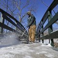 eremy Jordan, an employee of Fayetteville’s Department of Parks and Recreation, clears a bridge at W...