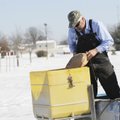 Marty Townsend, with the city of Rogers, pours a bag of rock salt Monday to use in de-icing Rogers r...