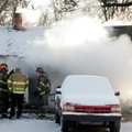 Rogers firefighters talk Monday morning as smoke billows from a house in northeast Rogers. No fatali...
