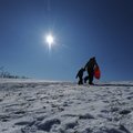 Teena Potts helps her 5-year-old daughter, Ryland, carry her sled up the hill in front of their hous...
