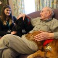 Natalie Williams and her two therapy dogs, Sophie (left) and Penny, visit with Norman Simons on Mond...