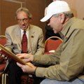 Former Arkansas basketball coach Eddie Sutton, left, talks with Jim Woodruff as he is shown some pho...