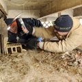 Bryan Johnson, right, and Jason Mitchell, both with Mayes Plumbing and Heating, work to gain access ...