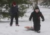 Matthew Redfield, 7, right, of Bentonville, hauls his sled Wednesday up a hill in Bentonville. Redfield was sleding with his brother and two cousins while on an extended holiday break.
