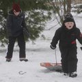 Matthew Redfield, 7, right, of Bentonville, hauls his sled Wednesday up a hill in Bentonville. Redfi...
