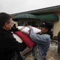 SHELTER FROM THE STORM: Jim Ed Summers, left, hands donated blankets and pillows to Preston Boswell ...