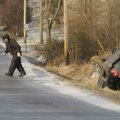 A tow truck driver from A & E Towing prepares to right a Jeep overturned Thursday while trying to ne...