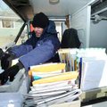 Lance Swift, a mail carrier with the Postal Service, sorts mail in his truck Thursday while on his r...