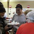 Nelson Chavers, from left, gets a warm meal Thursday from Gene George, Springdale Senior Center volu...