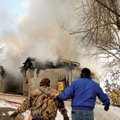 Annette and Carl Ruppert make their way up a slippery ice-covered slope to get to the burning home o...