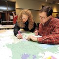 MAPPING OUT THE FUTURE
Natalie McBee, center, and David Orr mark the routes Sunday that they use to...