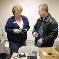 Officer Mike Peters, right, exchanges his cell phone Friday with Rose Lawrence, administration assis...