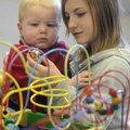 Dotty Fries, 12, right, and Griffin Kelley, 1, play with toys Monday at the Springdale Public Librar...