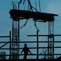    A construction worker walks along the top of the Garland Center that is under construction on Gar...