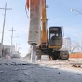 An operator in a track-mounted jack hammer makes short work Tuesday of perforating Northwest Second ...