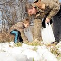 GRASS GATHERERS Jay Mealing and his son, Max, 6, gather grass to put under their beds Jan. 6 for Thr...