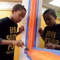 Rorick Anderson, 12, paints the trim around a window Saturday at the Elizabeth Richardson Center in ...