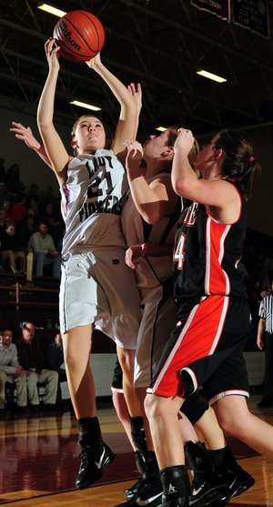 Gentry’s Kendra Boyd, left, puts a rebound up for two points over teammate Terra Jones and Gravette’s Samantha Vanotterloo on Tuesday in Gentry.