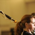 Rebecca Bercher wears earplugs as she plays the bagpipes during a rehearsal for the Ozark Highlander...