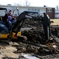Keith Austin digs a small hole to for soil samples Wednesday at the site for the future library at W...