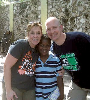Lori and Noel Tugwell of Siloam Springs pose with their newly adopted son, Louis, in Haiti on Thursday. The family is scheduled to fly home today.

